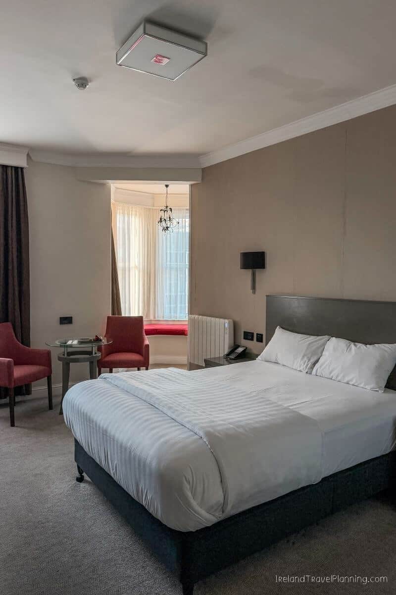 Comfortable hotel room in Cork City with a king-size bed and seating area.