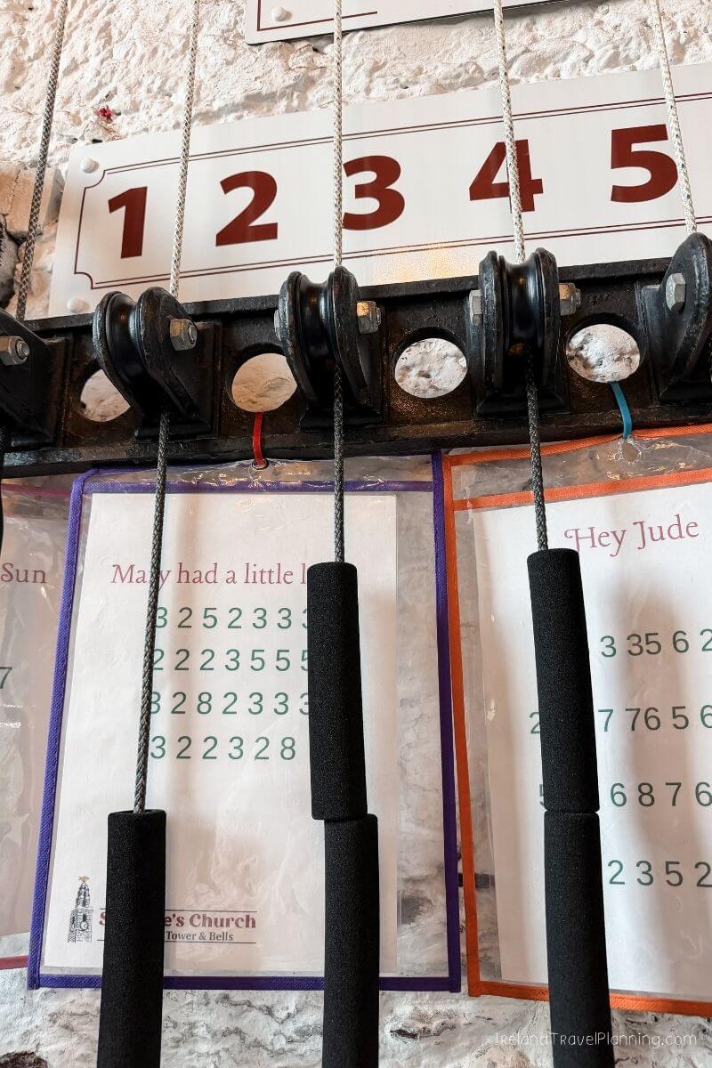 Bell tower ropes with sheet music for "Hey Jude" and "Mary had a little lamb" at Cork Church