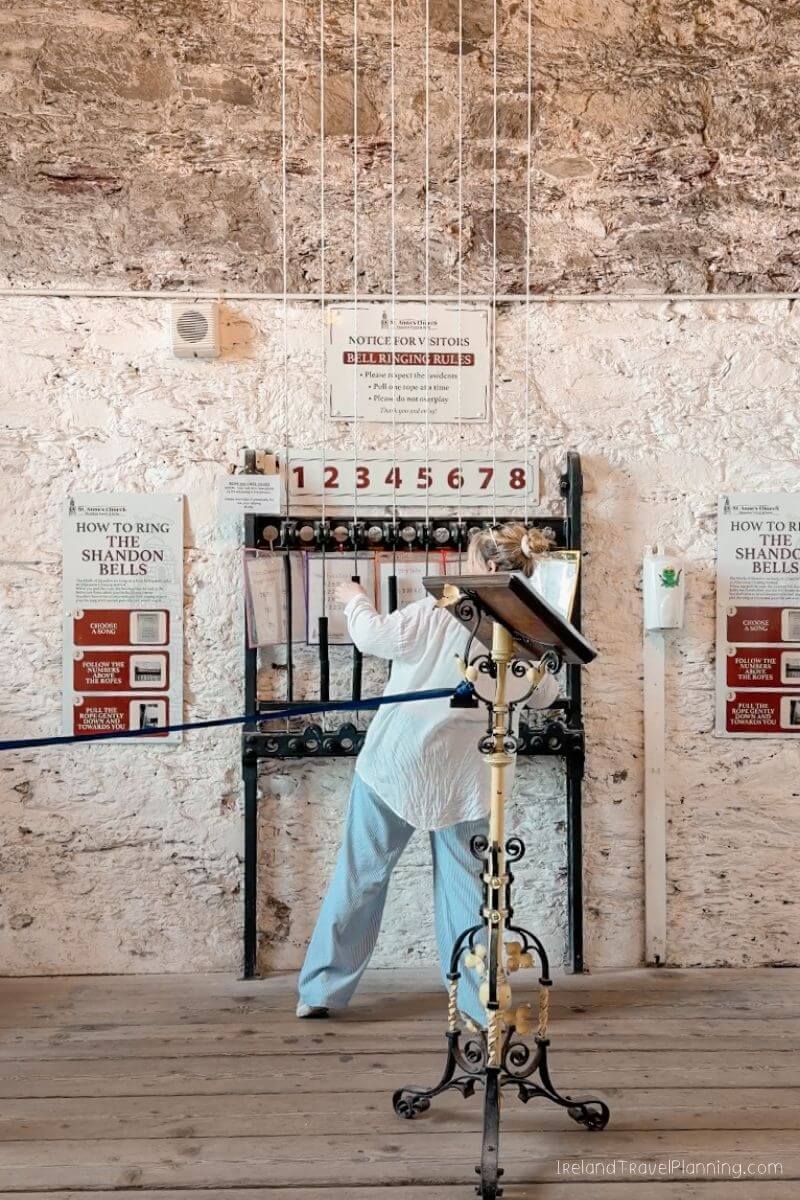 Woman rings Shandon Bells in Cork City, following instructions on the wall.