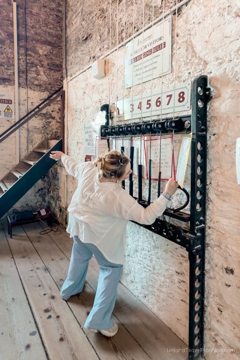 Woman ringing bell ropes in Shandon Bells tower, Cork City
