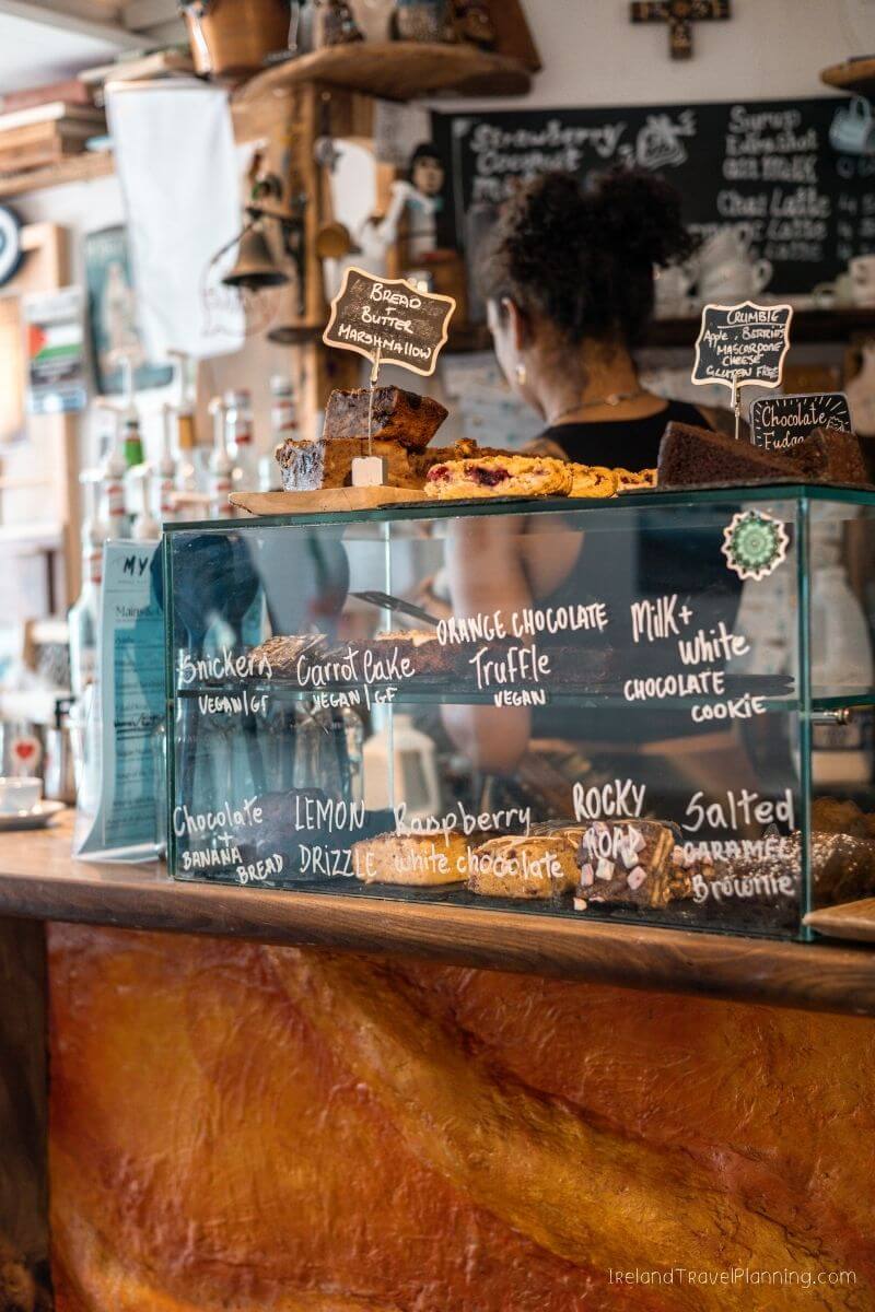 Vegan treats display case in bakery with woman in background