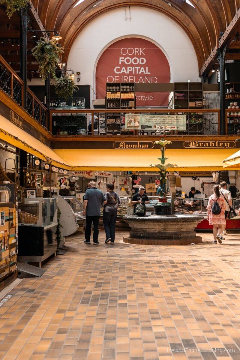 Cork Food Capital market with shoppers and sellers in vibrant indoor setting