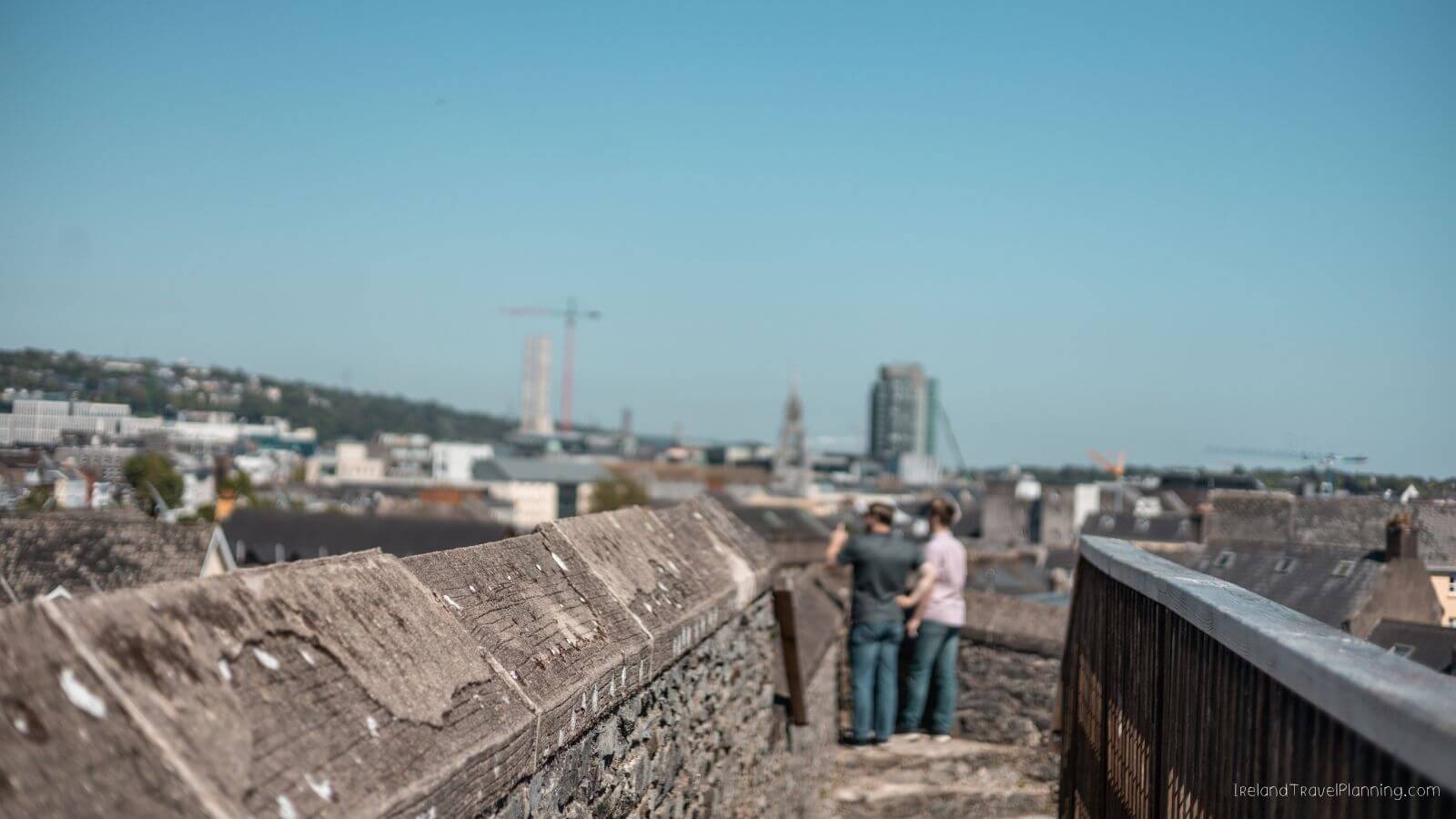 Couple admiring the Cork City skyline from the top of a castle wall