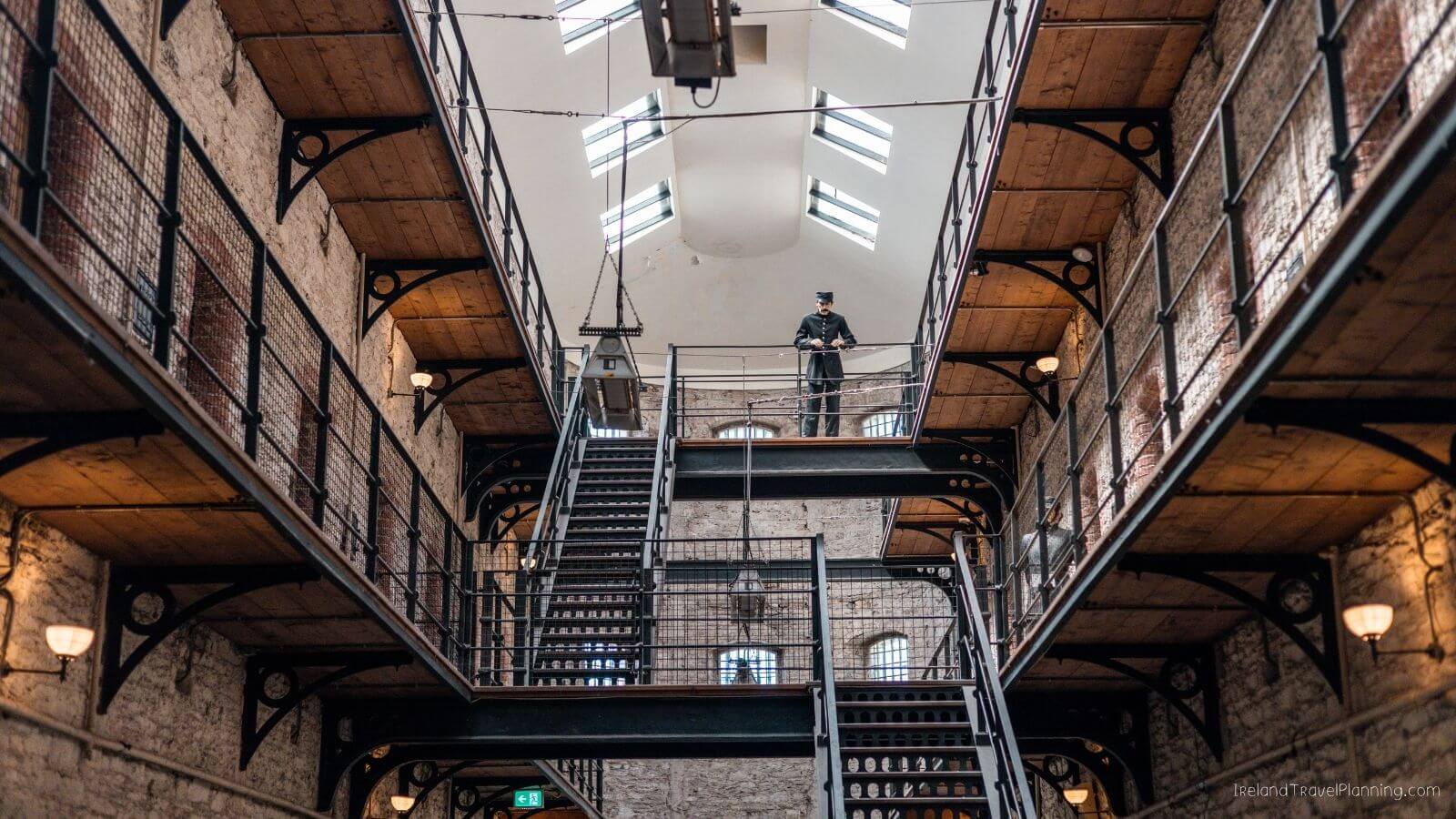 Guard at Cork City Gaol prison with staircases and arched windows