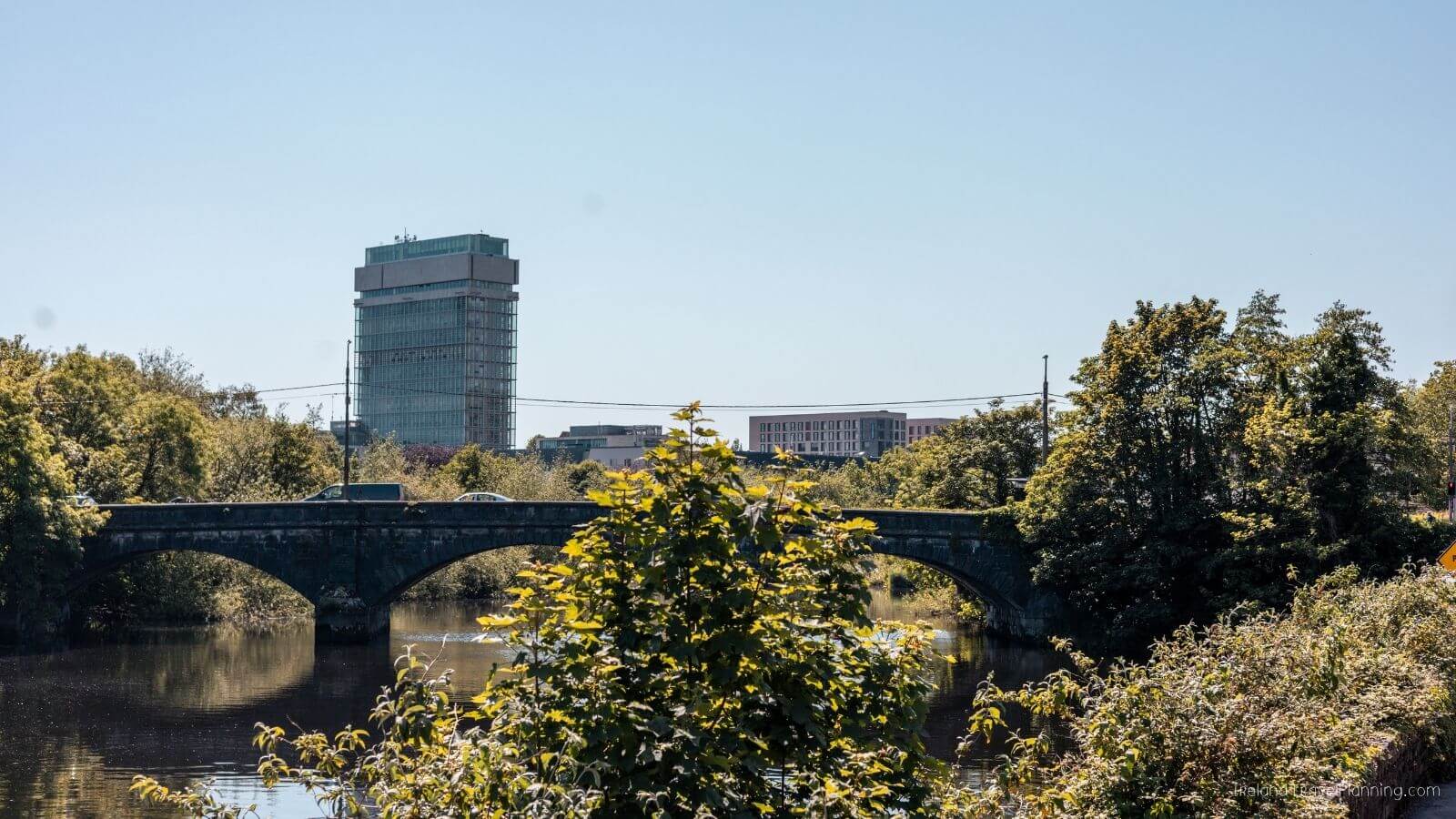 Bridge over a river with Cork City buildings in the distance