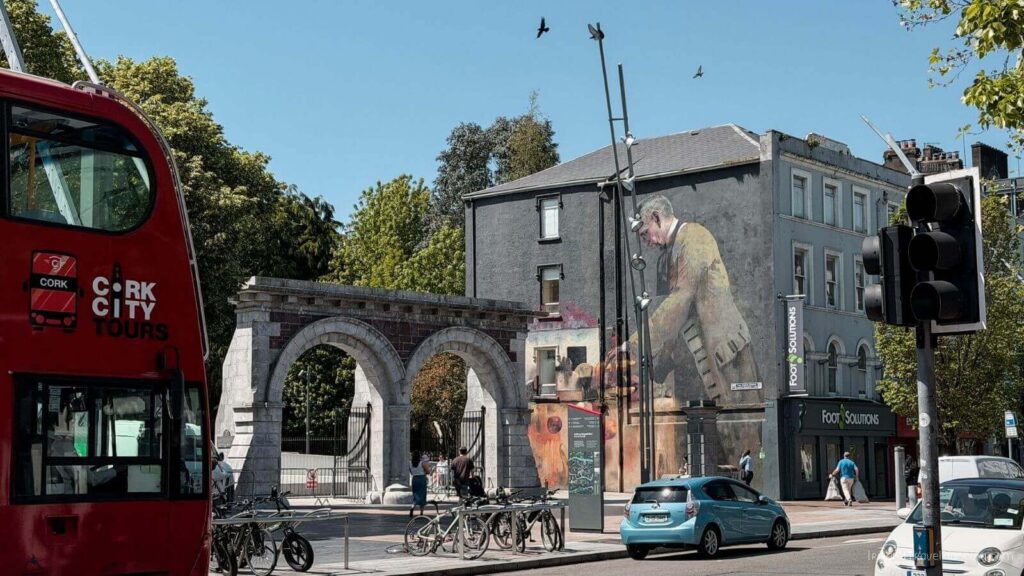 Cork City street scene with mural, bus, and traffic, showing things to do in Cork.