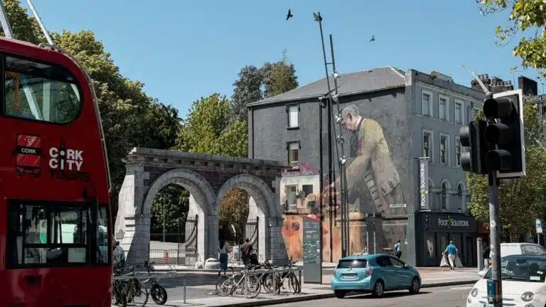 Cork City street scene with mural, bus, and traffic, showing things to do in Cork.