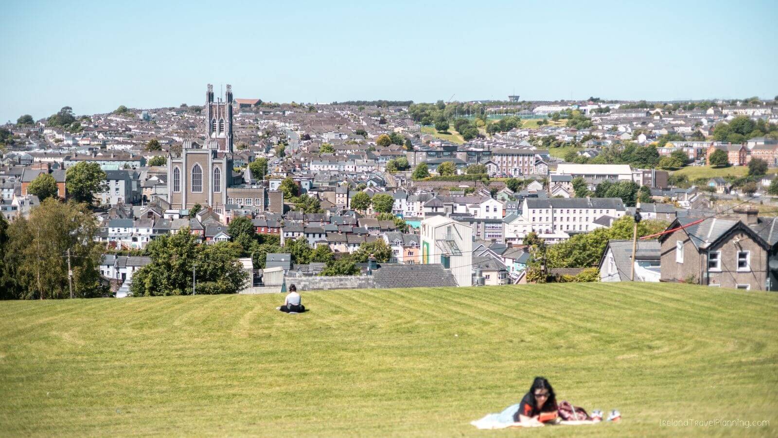 View of Cork City, Ireland, with St. Fin Barre's Cathedral and rolling green hills