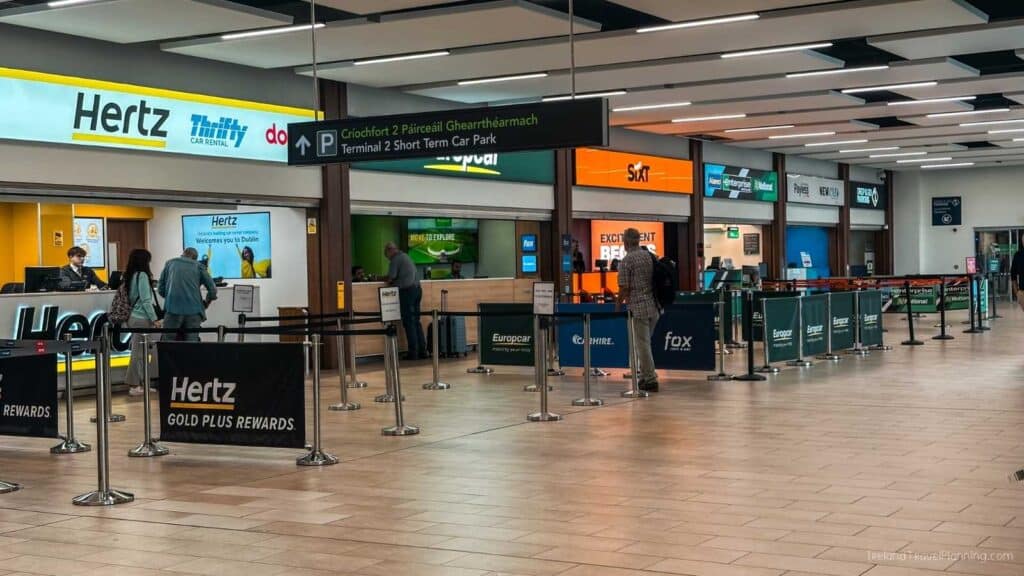 Hertz car rental desk at Dublin Airport Terminal 2, with Sixt and Europcar signs visible.