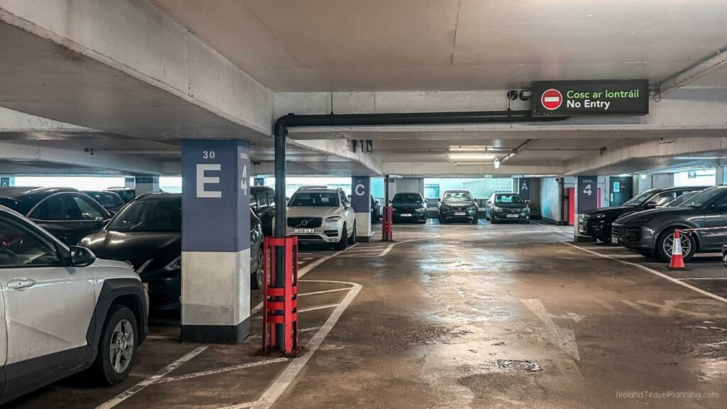 Interior of a multi-level parking garage with cars parked and "No Entry" sign.
