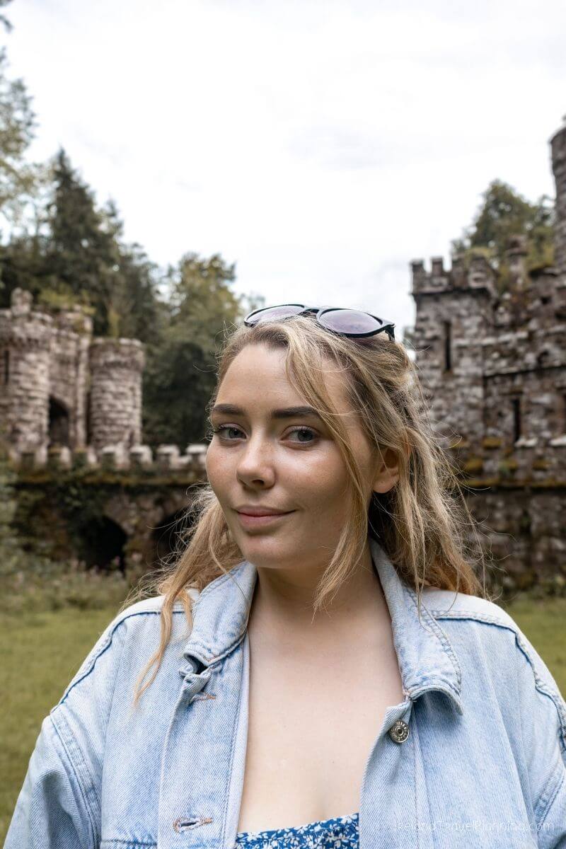 Young woman in denim jacket at Irish castle ruins, a hidden gem