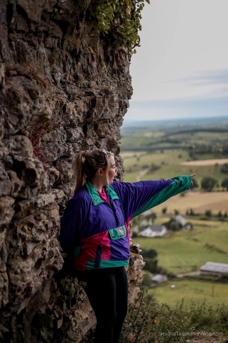 Woman pointing at a scenic view in Ireland, a hidden gem.