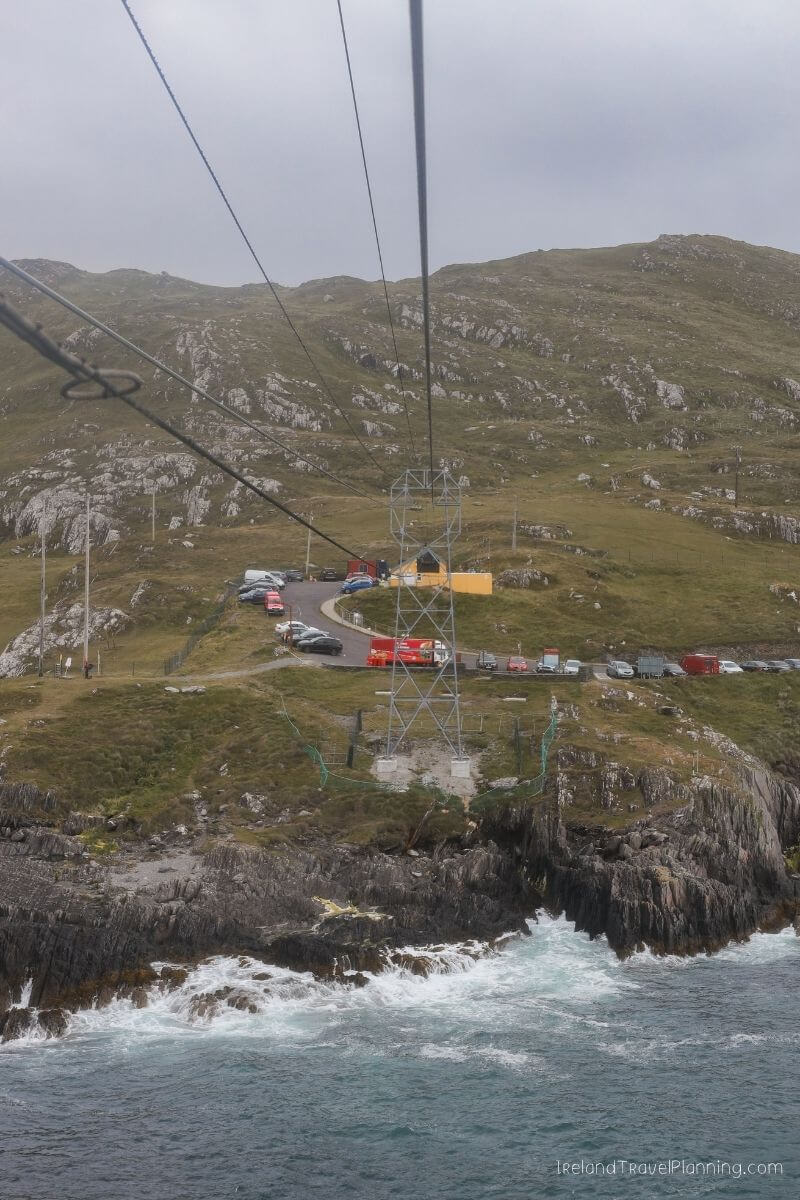 Cable car descends towards a visitor center near rugged Irish coastline