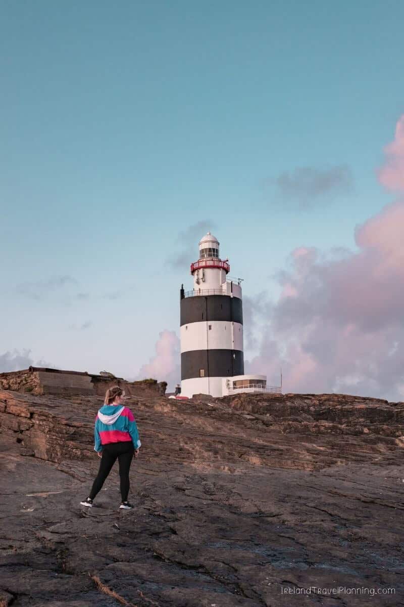 Woman looking at Hook Lighthouse, a hidden gem in Ireland
