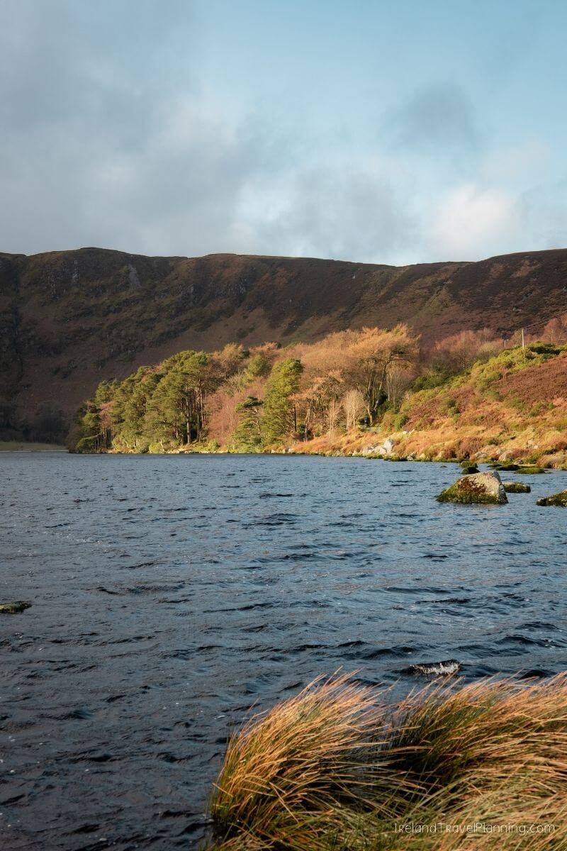 Serene lake and rolling hills in Ireland, a hidden gem.