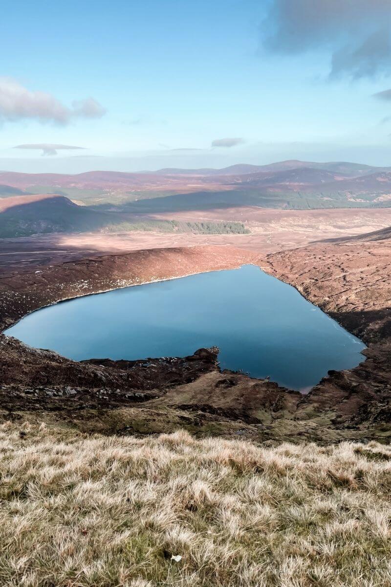 Serene heart-shaped lake nestled in the Irish mountains, a hidden gem.
