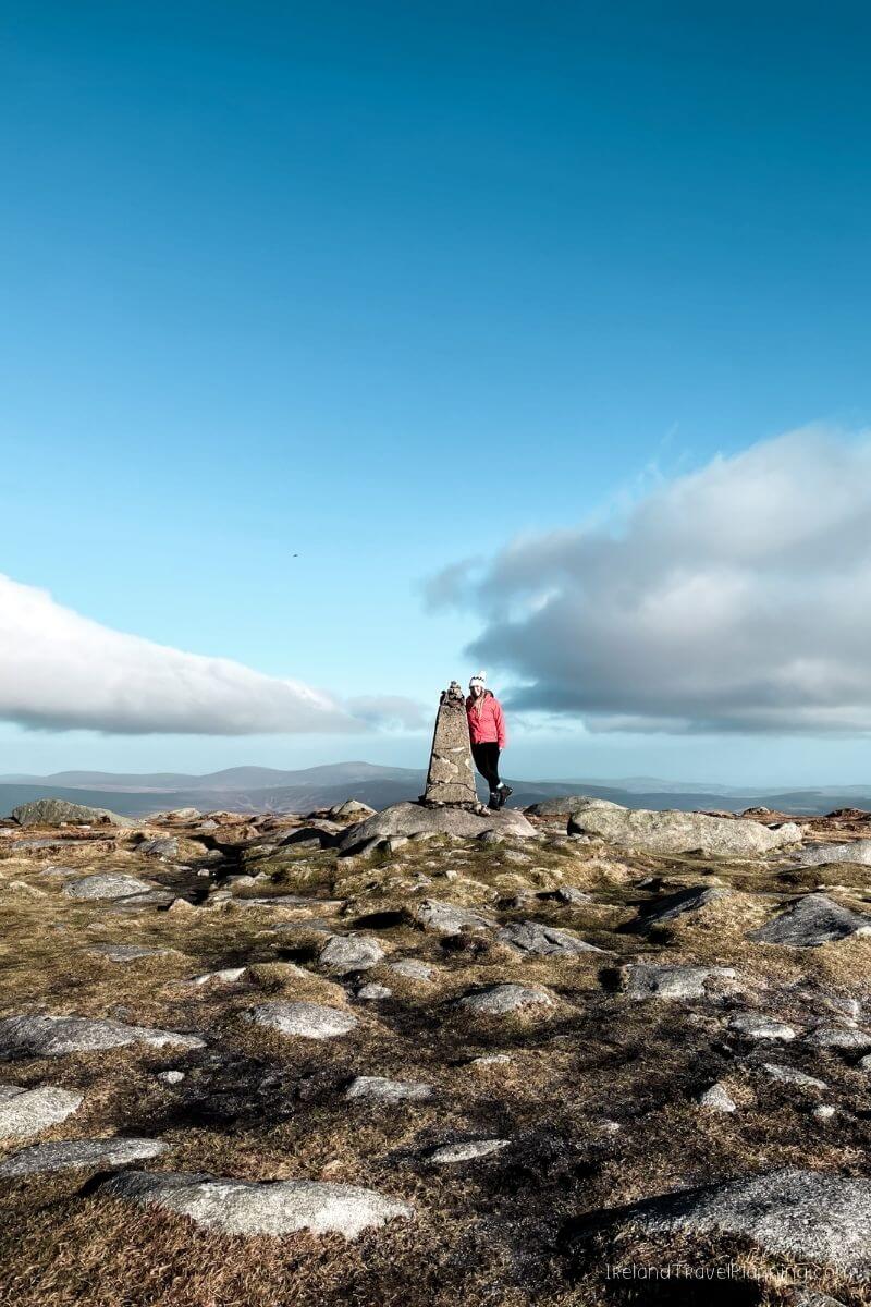 Woman at cairn on Irish hilltop, Ireland Travel Places