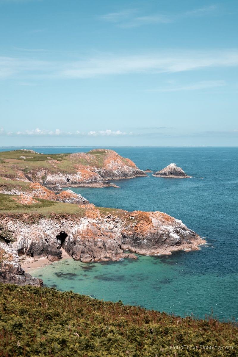 Rugged Irish coastline with sea caves and clear turquoise water