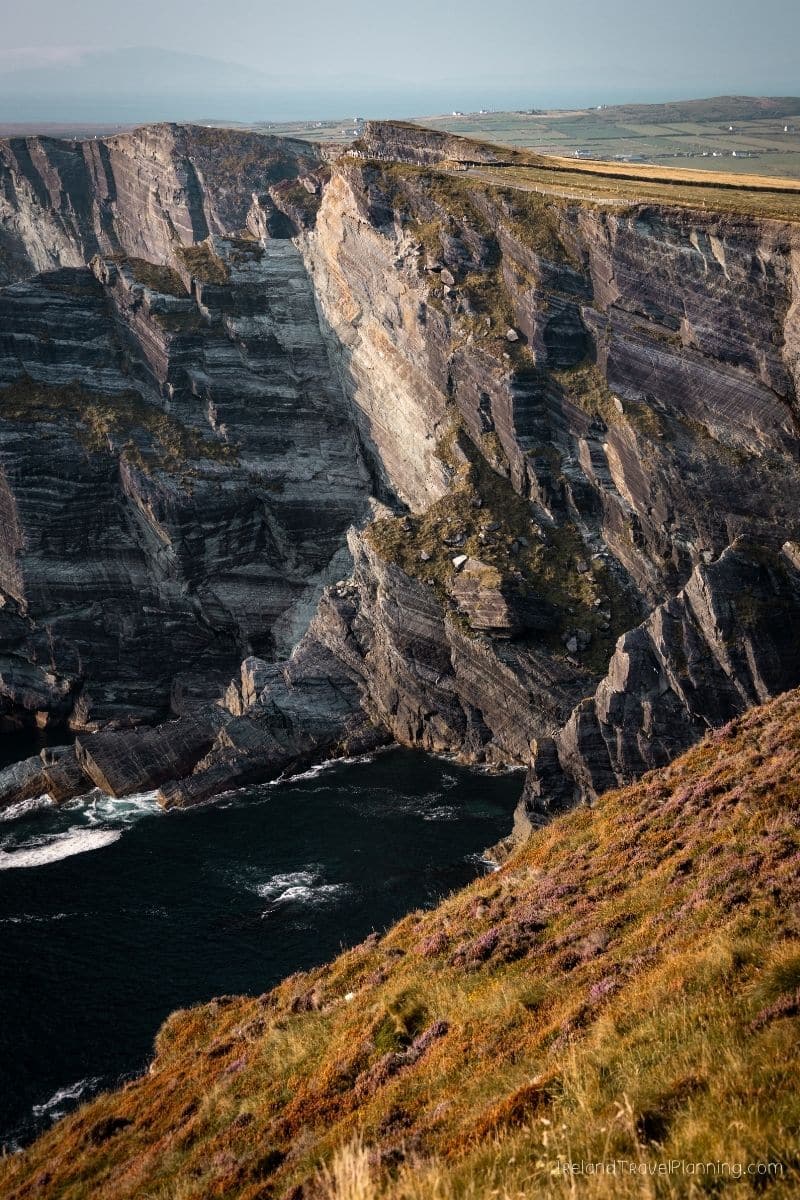 Dramatic cliffs of Ireland's coast, a hidden gem, with ocean waves below.