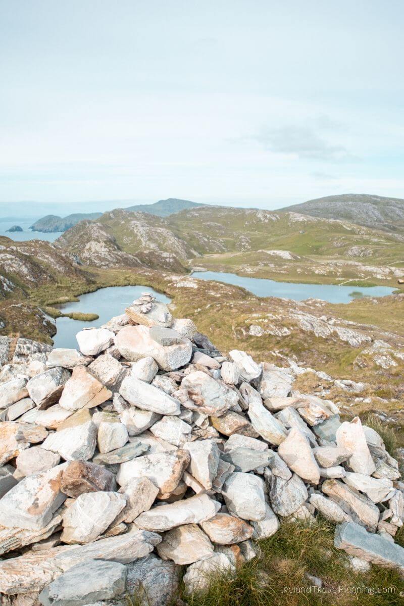 Cairn of stones overlooking lakes and hills in Ireland