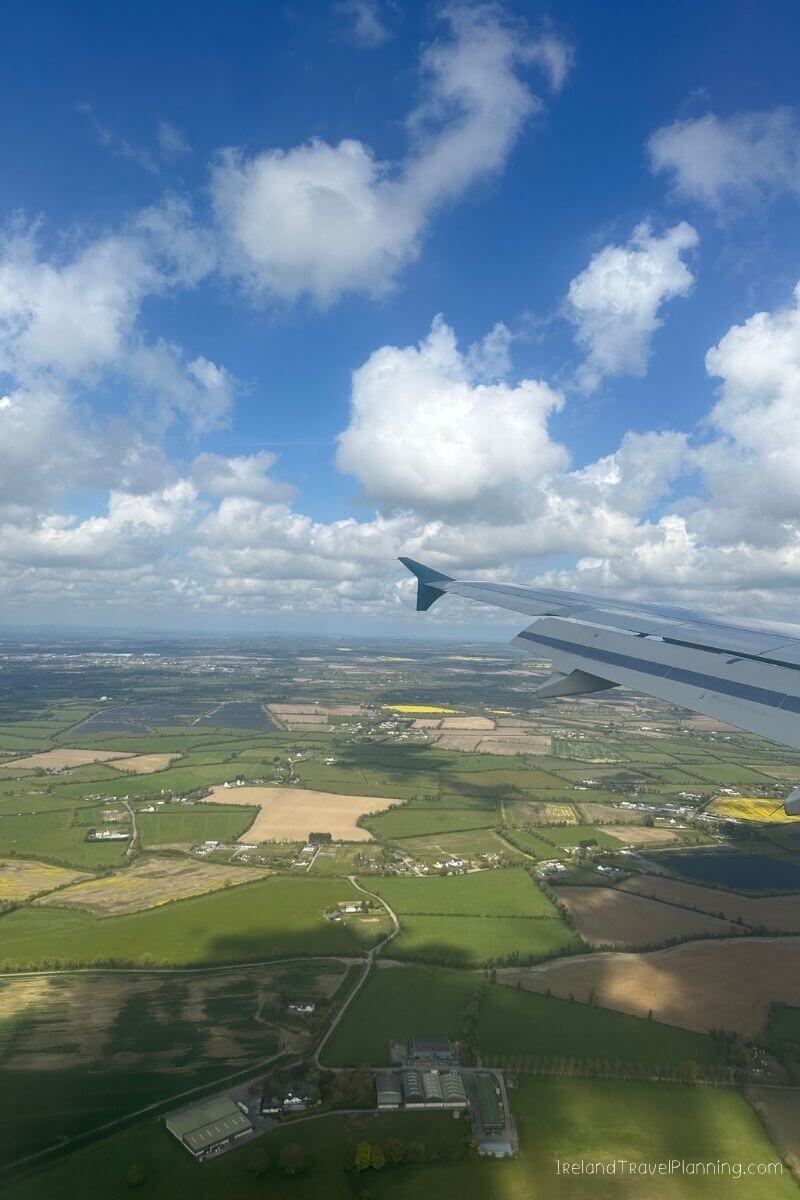 Aerial view of green Irish countryside with airplane wing in foreground