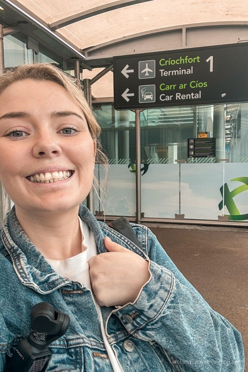 Woman at Shannon Airport Terminal 1, showing signs for Car Rental and Terminal 1.