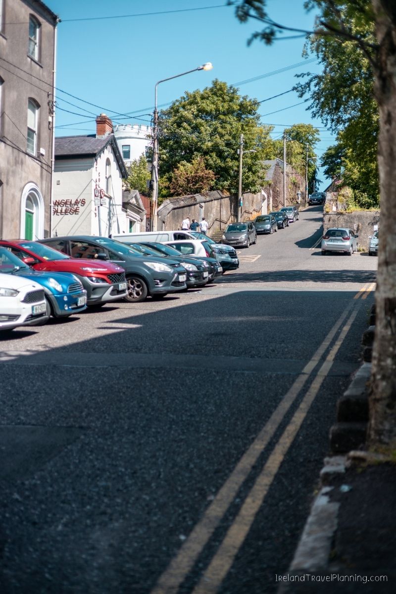 Cars parked on a street in an Irish town, relevant to renting a car in Ireland.