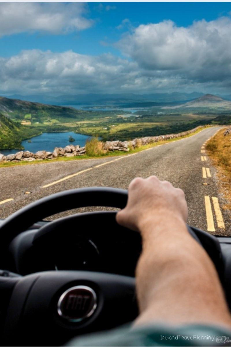 Driving a car on a scenic Irish road with a lake and mountains