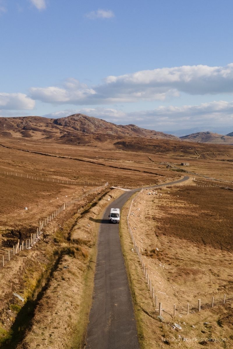 Campervan driving on a rural road in the Irish countryside