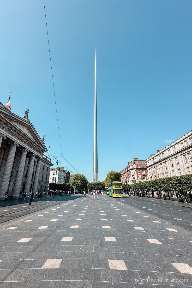 Spire of Light monument in Dublin, Ireland, with Georgian architecture and a yellow bus.