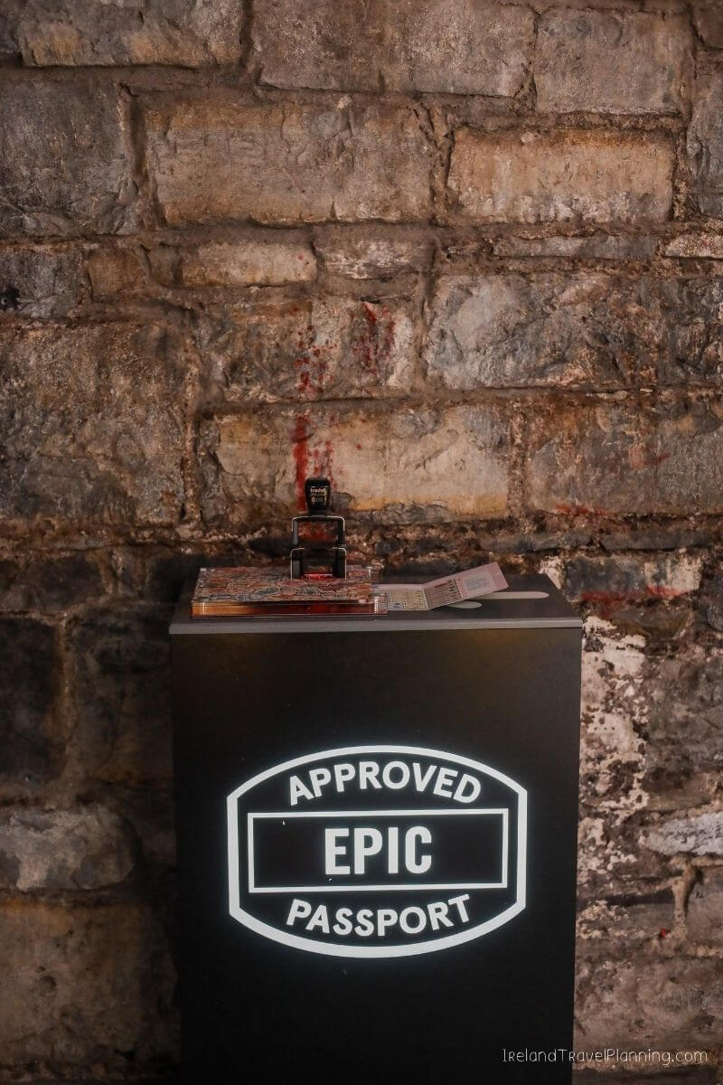 Approved EPIC Passport stamp station with red ink on a stone wall.