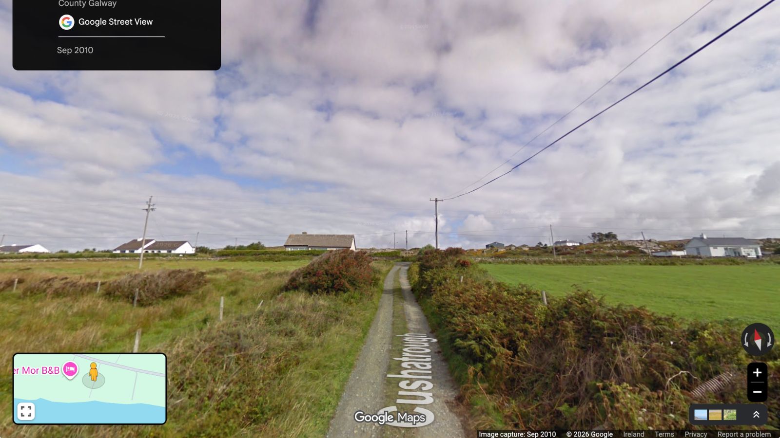 Rural road in County Galway, Ireland, leading to houses.