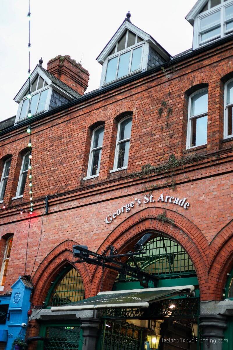 George's St. Arcade Dublin, red brick building with arched windows and string lights