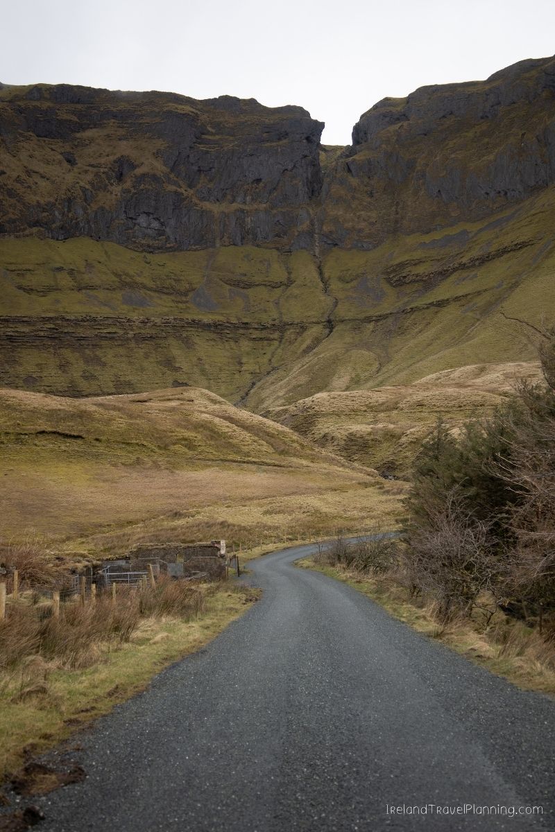 Scenic road leading to a dramatic mountain valley in Ireland.