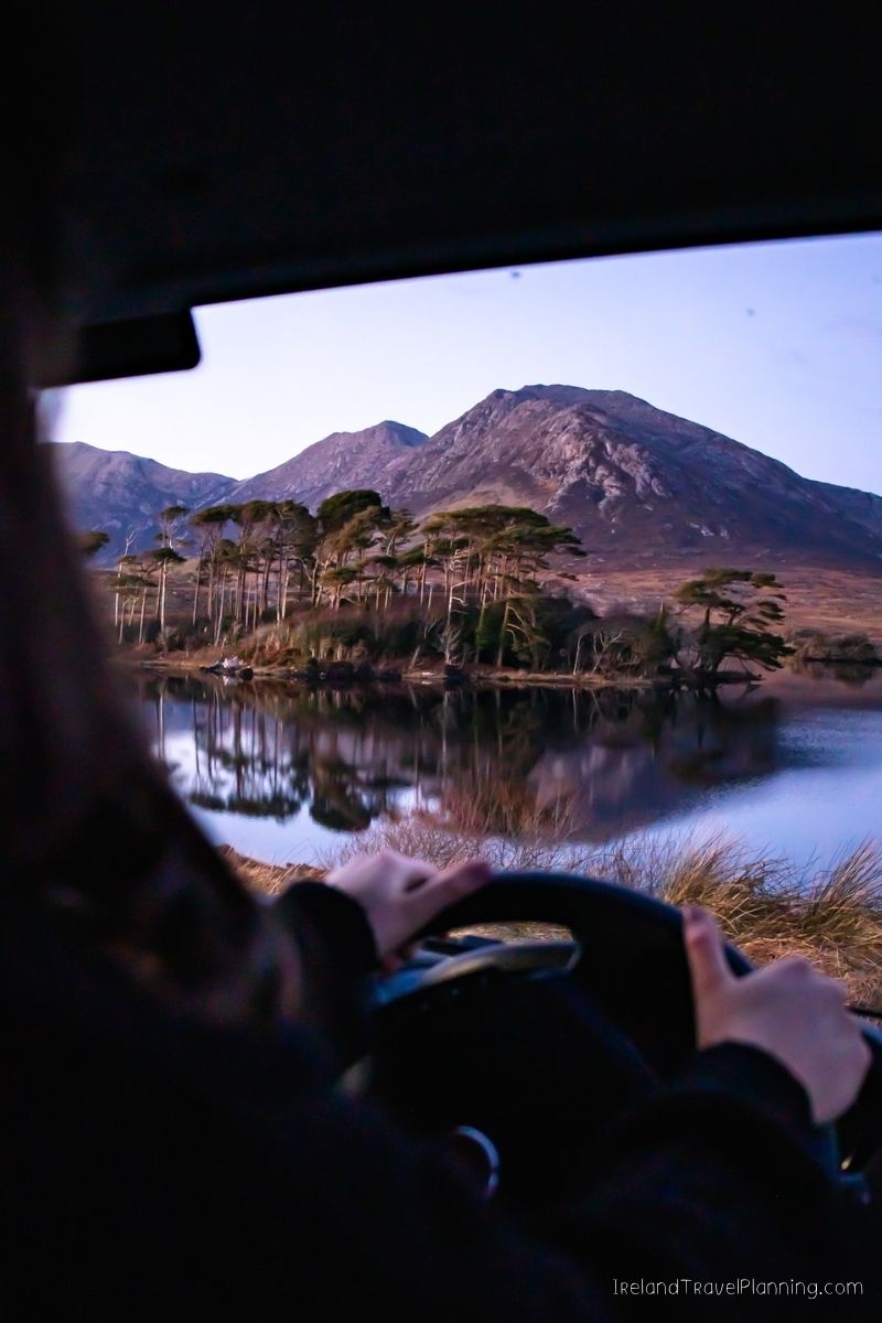 Driving through Connemara, Ireland: Mountains, lake, and pine trees
