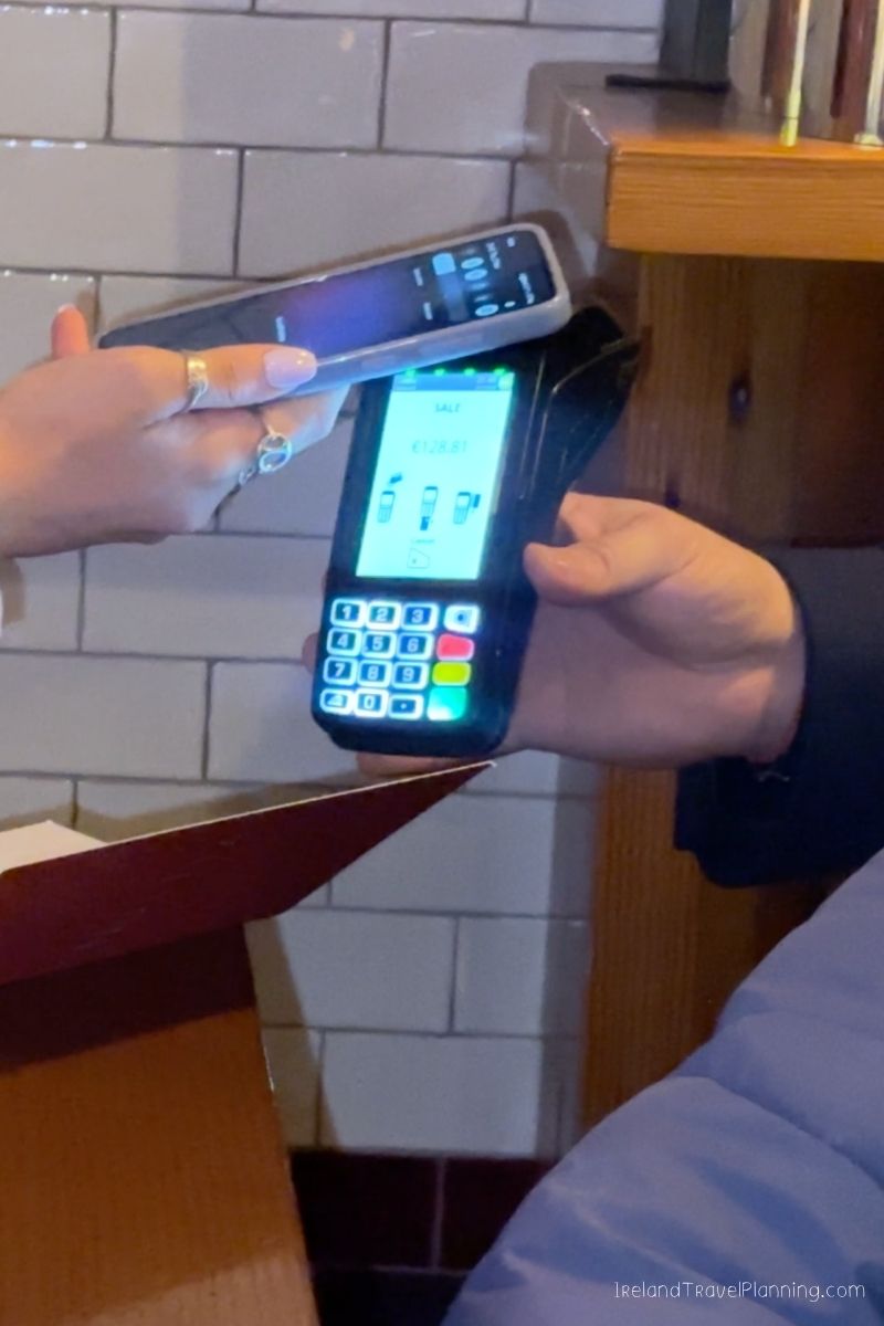 Paying for an Ireland trip with contactless payment on a card machine.