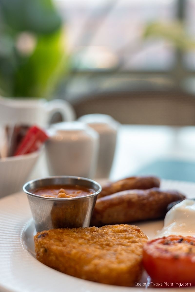 Full Irish breakfast with sausages, beans, hash brown, and tomato.