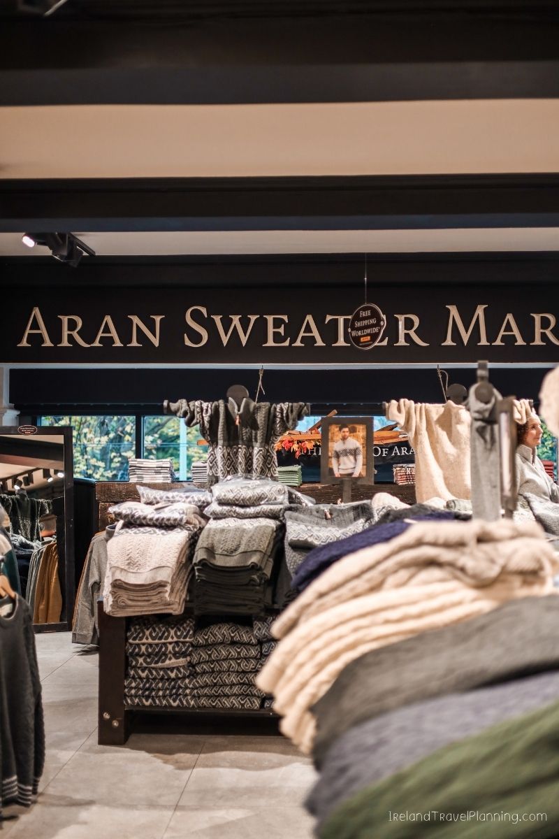 Aran Sweater Market sign and stacks of wool sweaters in Ireland