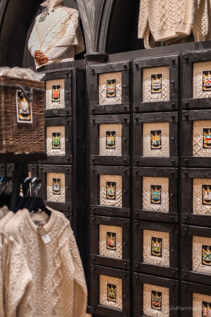 Irish wool sweaters with crests displayed in a shop, part of an Ireland trip.