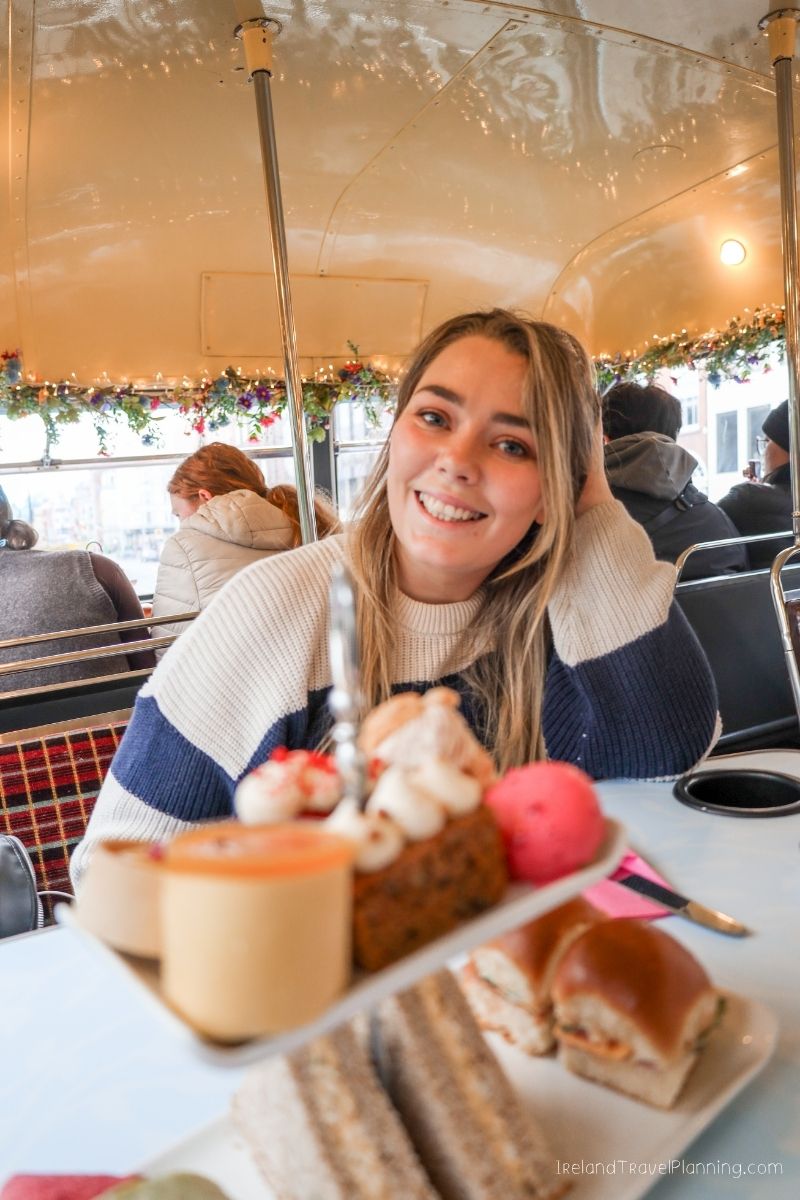 Woman enjoying afternoon tea on a festive bus tour in Ireland