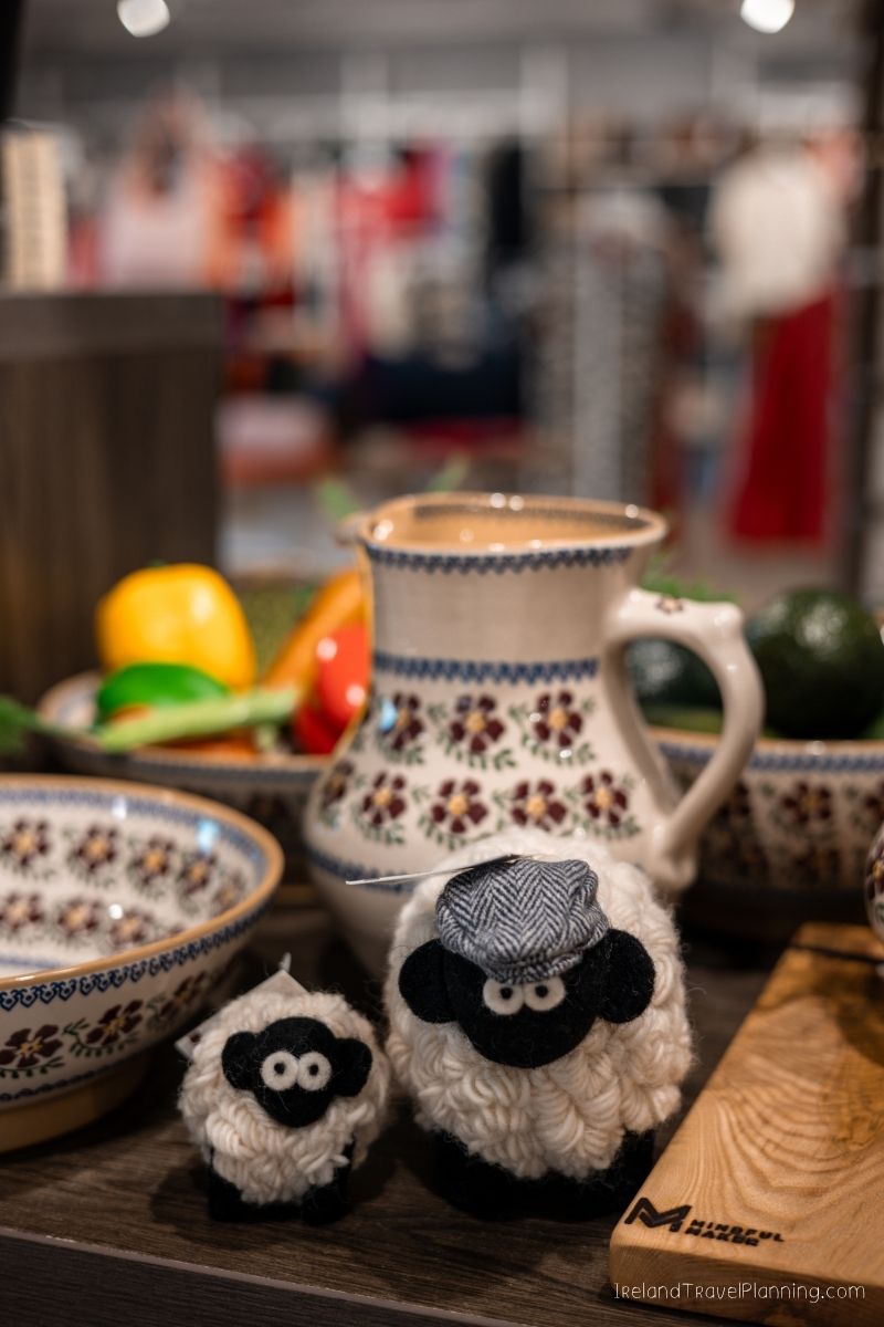 Cute sheep souvenirs and pottery on a shelf, possibly in Ireland.