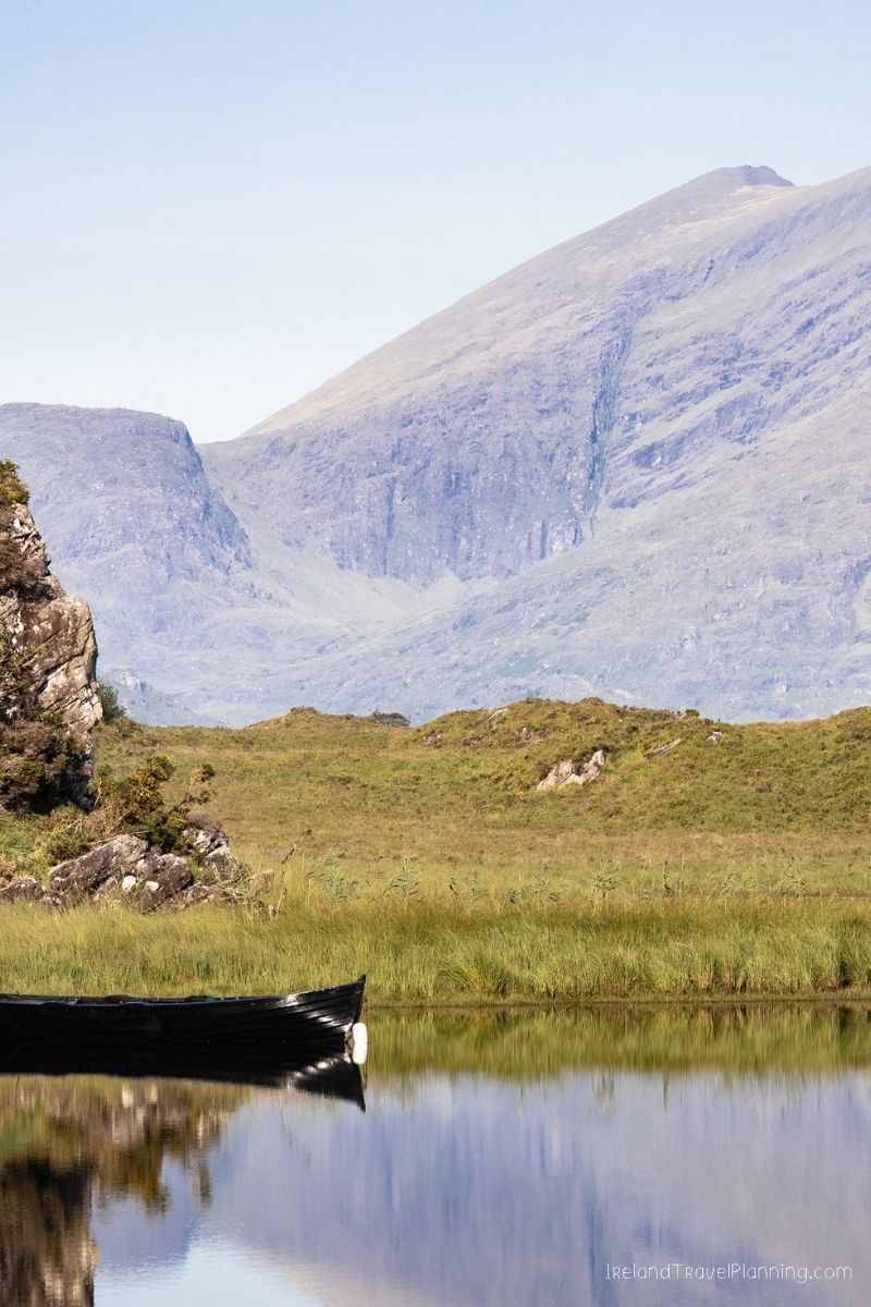 Rowboat on a tranquil lake with mountains in the background, Ireland