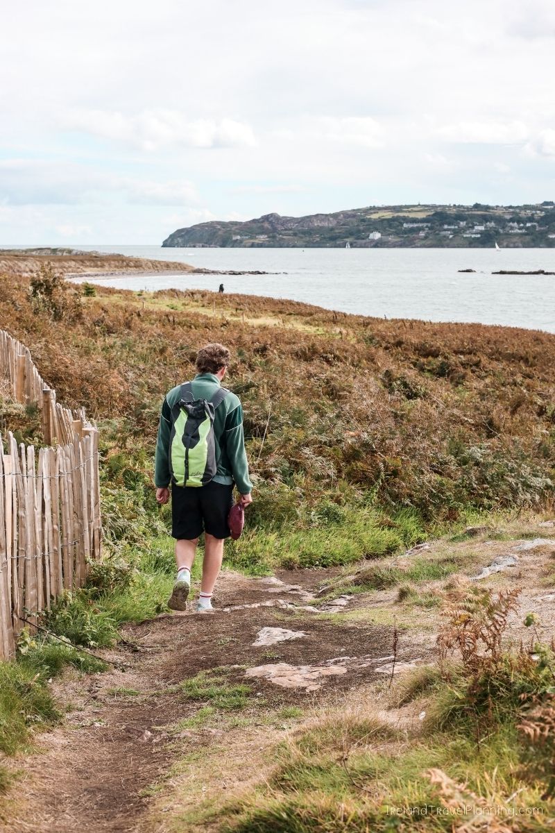 Man hiking along the coast of Ireland with a backpack.