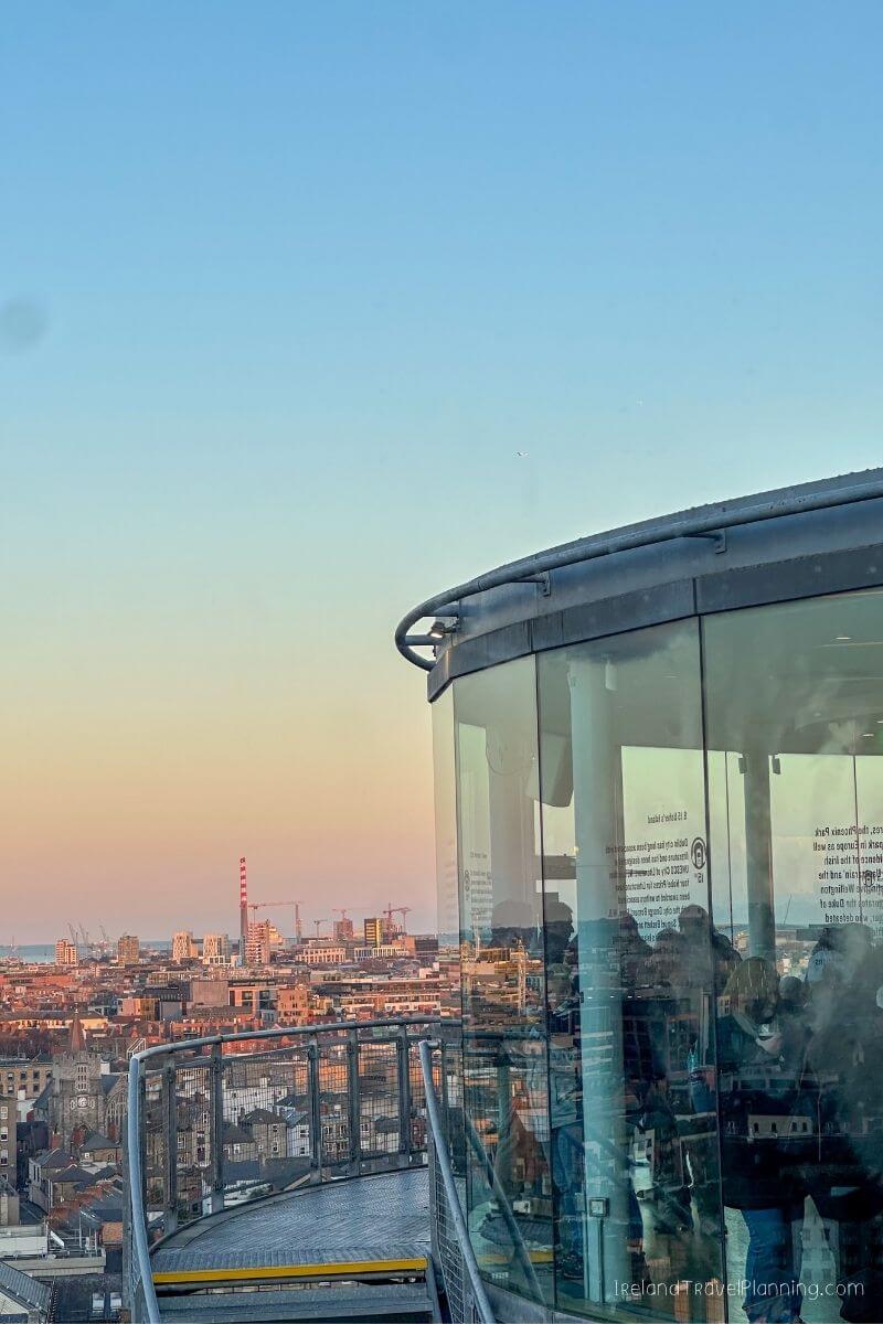 View from Dublin's Sky Bar at sunset, showing city skyline and people inside.