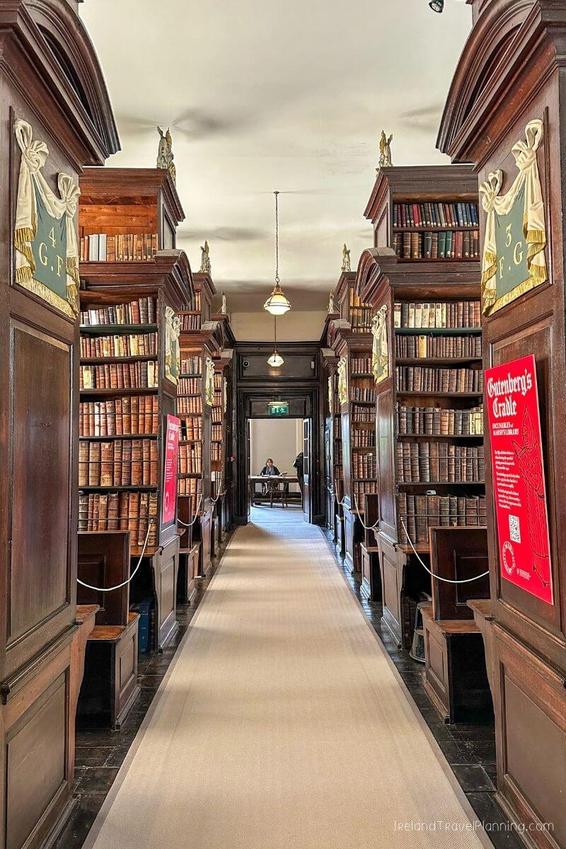 Gutenberg's Cradle exhibition in a historic library with wooden shelves and books.