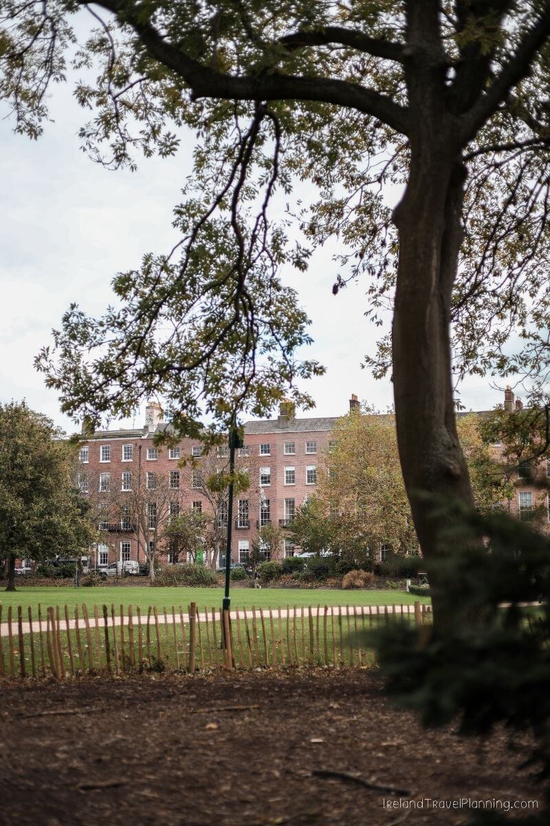 Georgian terrace houses behind a green park in London, UK.