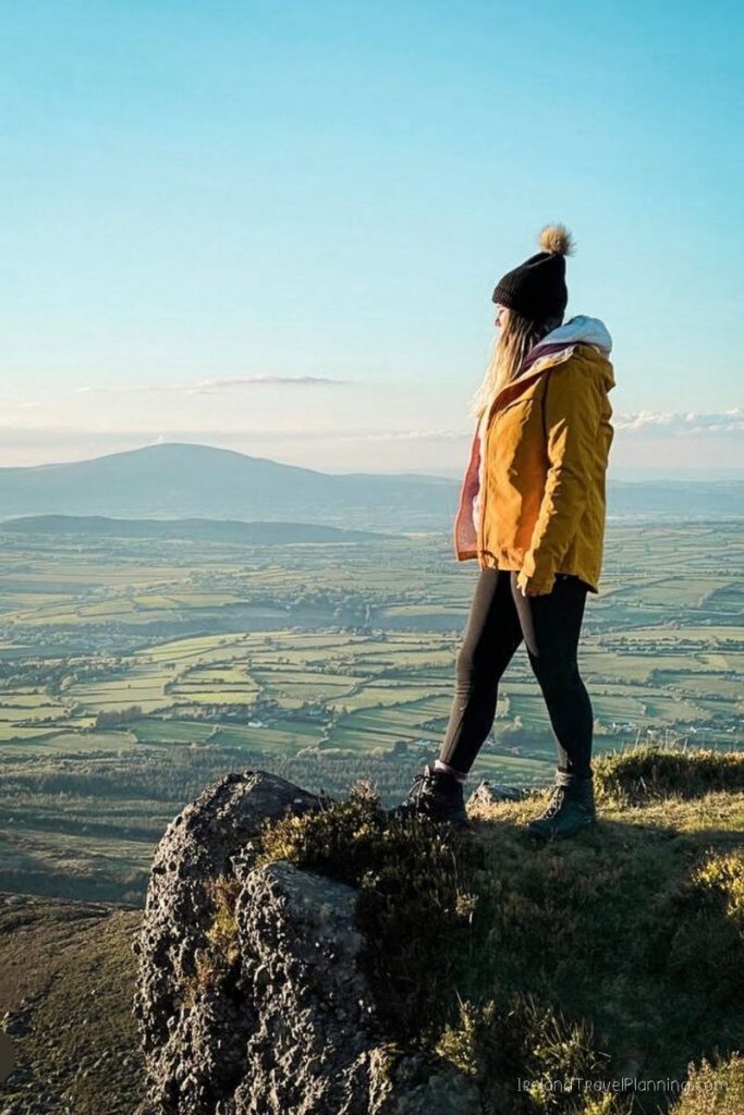 Woman in yellow jacket on a scenic overlook in Ireland