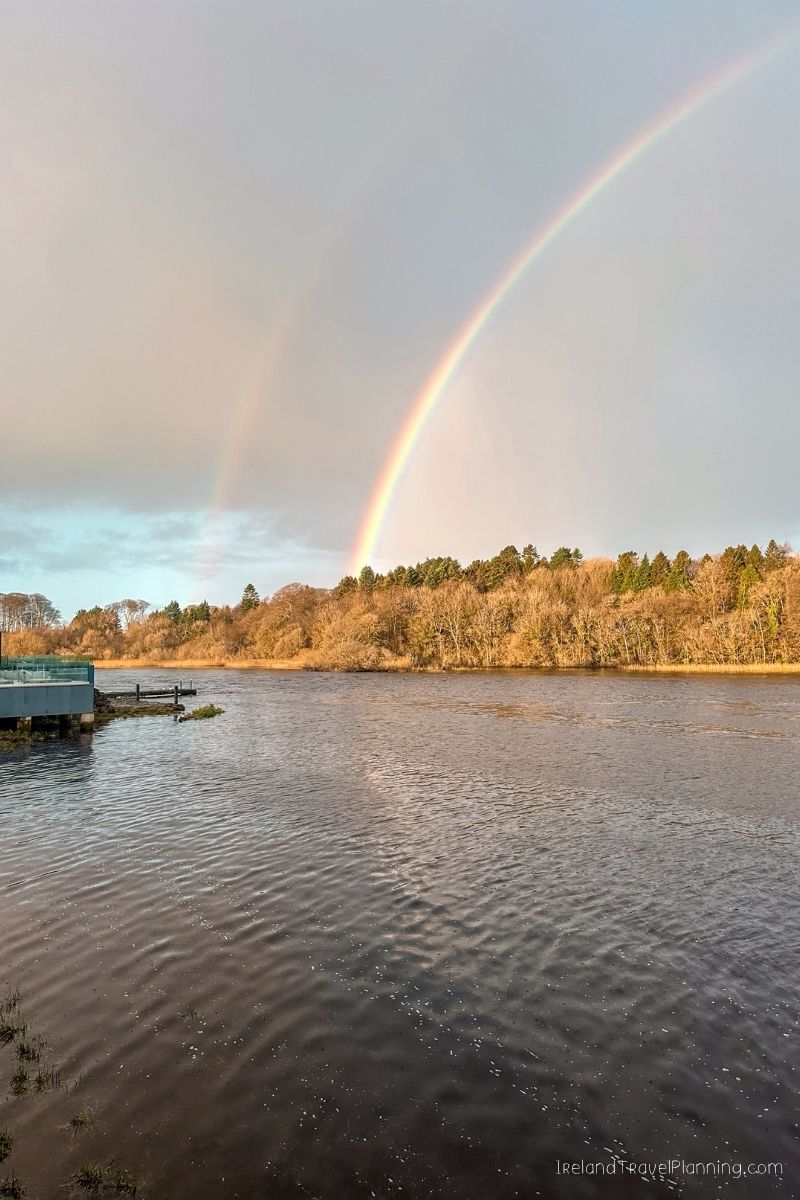 Double rainbow over a wide river and autumn trees in Ireland