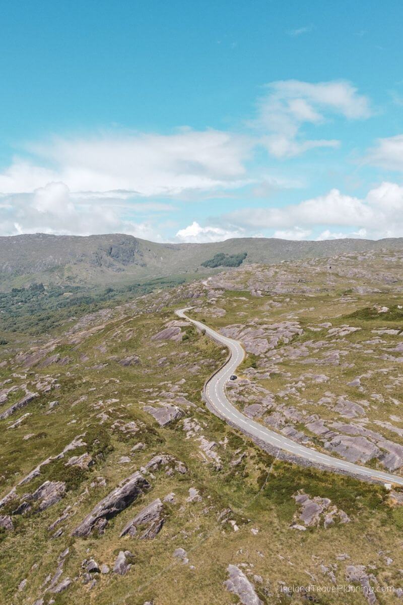 Winding road through rugged Irish landscape, ideal for driving in Ireland.